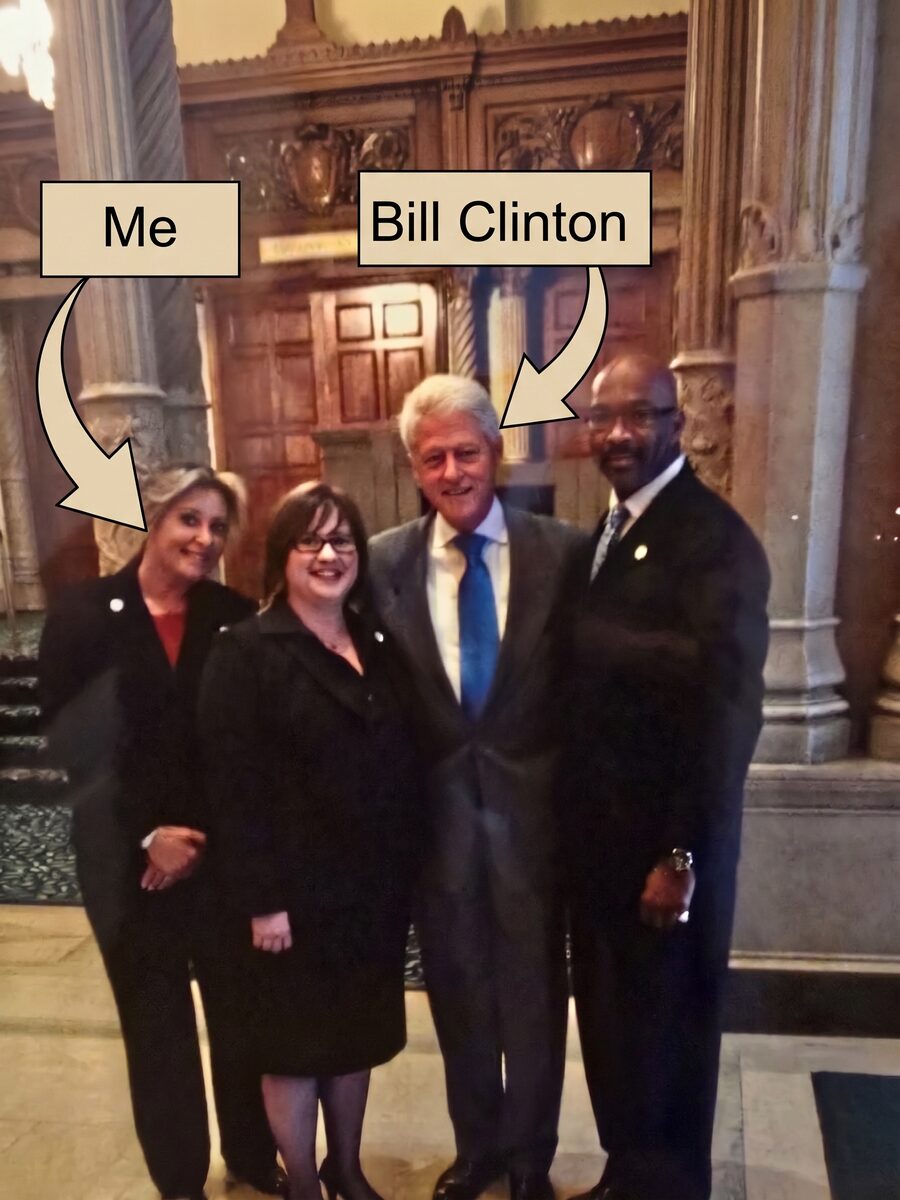 Valerie Lehman with President Bill Clinton and two colleagues in the foyer of the Millennium Biltmore, with a hand-drawn arrow labeled Me.