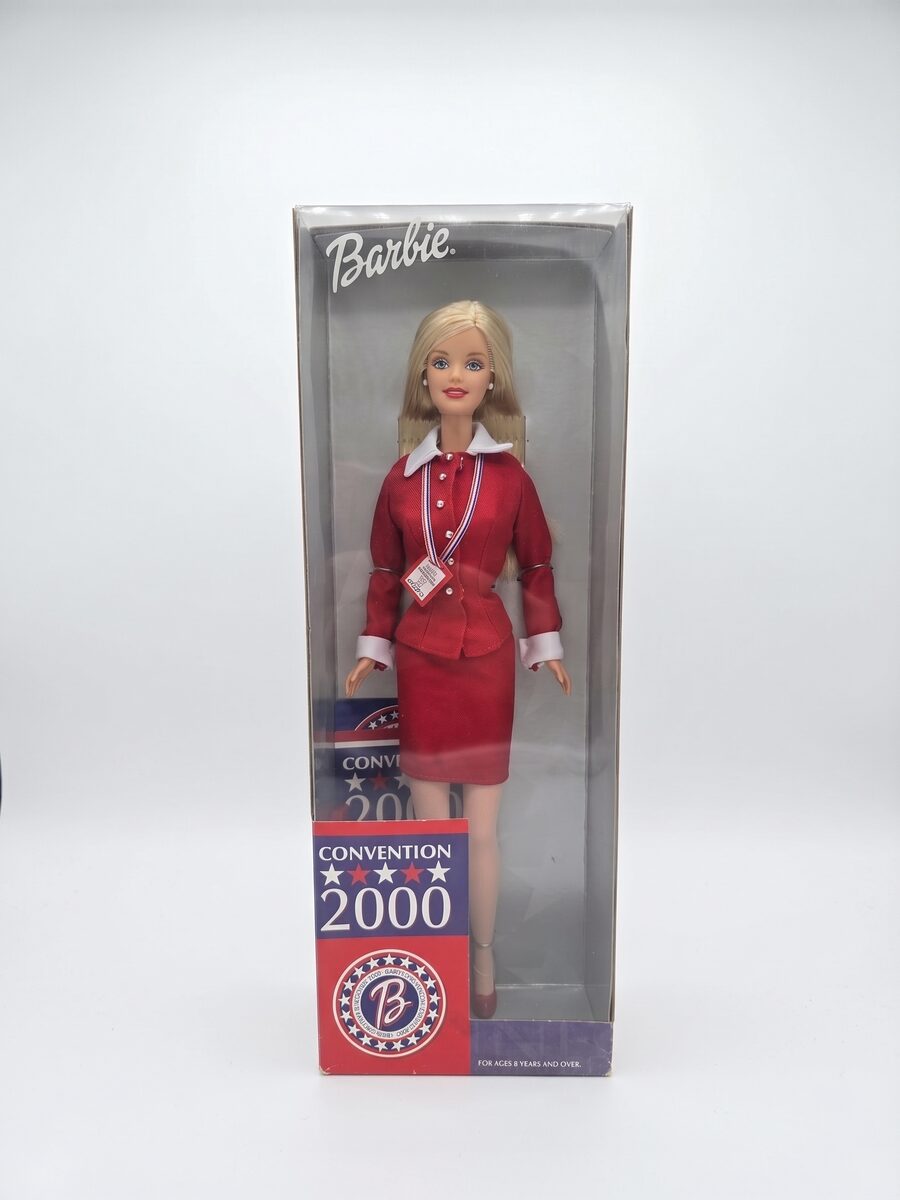 A Convention 2000 Barbie doll in a red suit, still sealed in its original box.